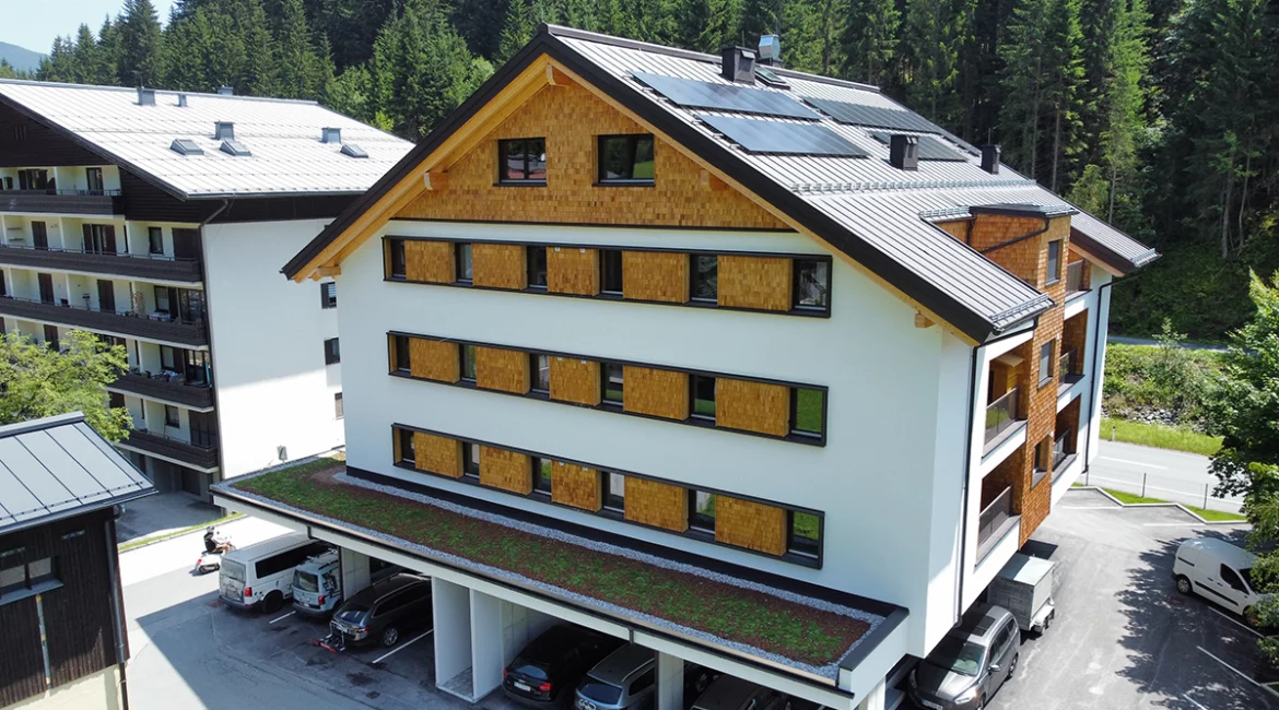 Drohnenaufnahme vom Bauprojekt in Saalbach-Hinterglemm mit Holzschindelfassade