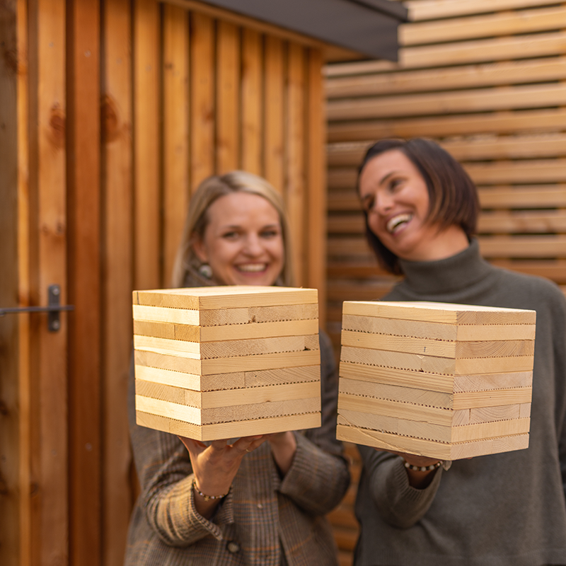 Zwei Personen die den Wandaufbau in der Hand halten.